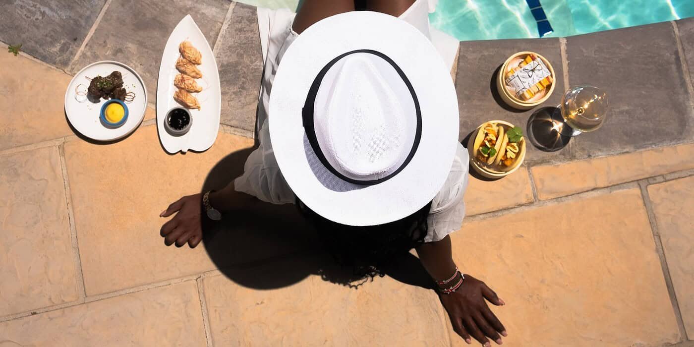 Luxurious poolside dining experience at Palm House Boutique Hotel and Spa, featuring gourmet dishes, refreshing drinks, and elegant relaxation by the pool in Stellenbosch, South Africa.